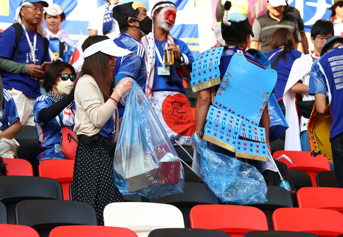Japan supporters collect garbage after Japan v Costa Rica match